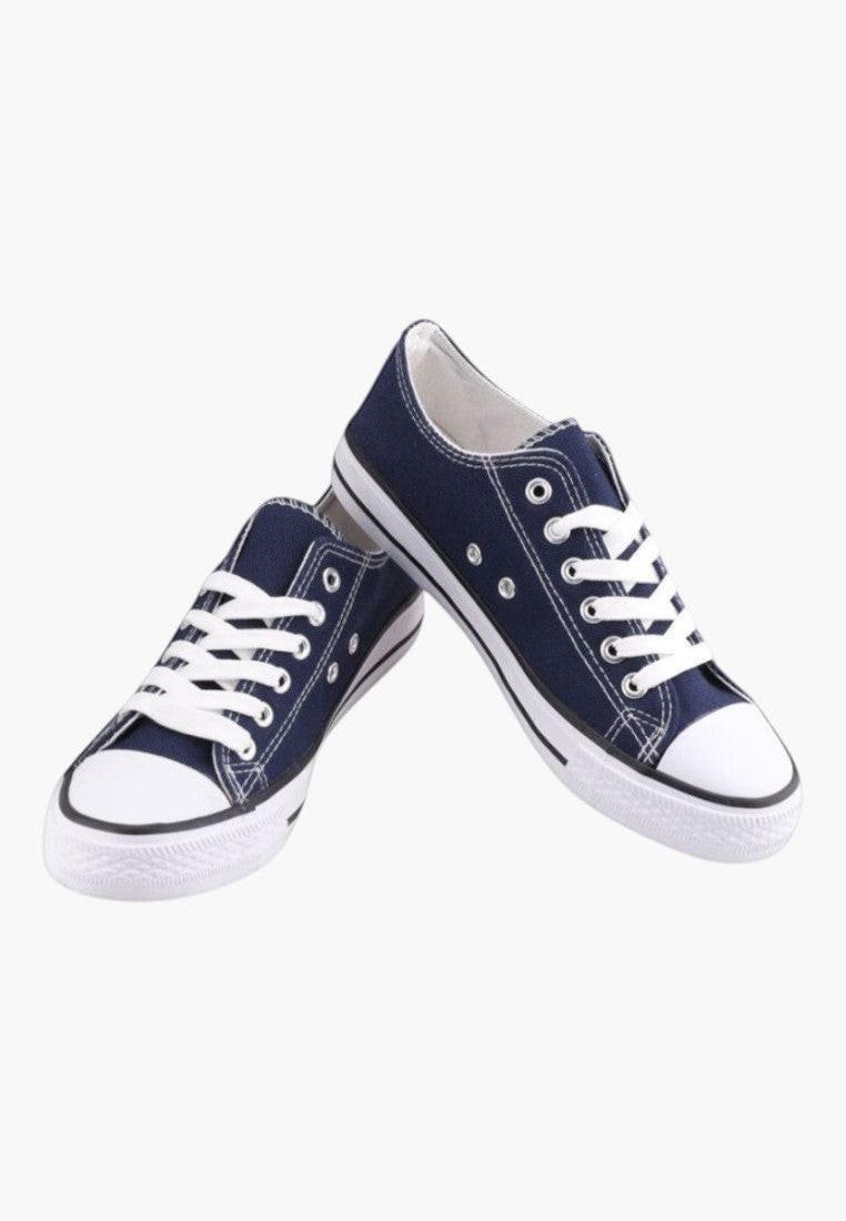 Granatowe trampki z białymi sznurówkami w stylu lifestyle na białym tle.