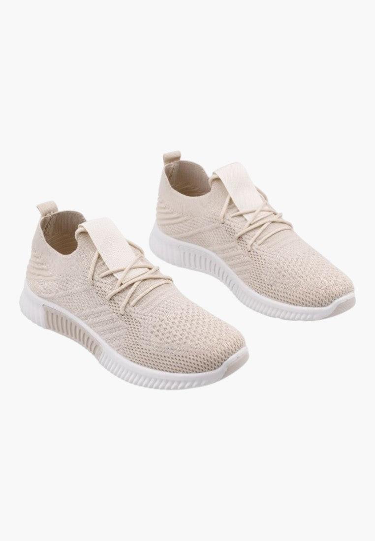Jasno beżowe buty sportowe damskie w stylu lifestyle na białym tle.