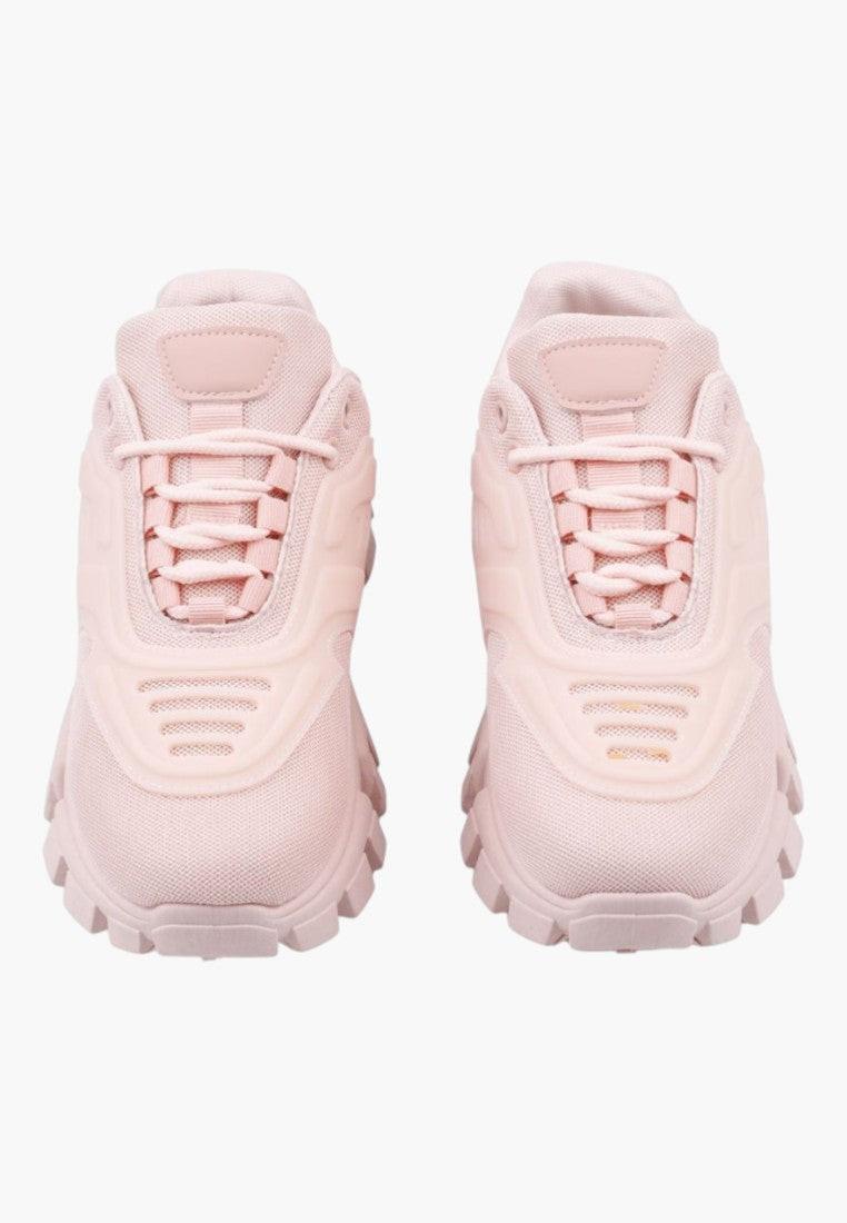 Zbliżenie na teksturowaną podeszwę jasnoróżowych sneakersów damskich.