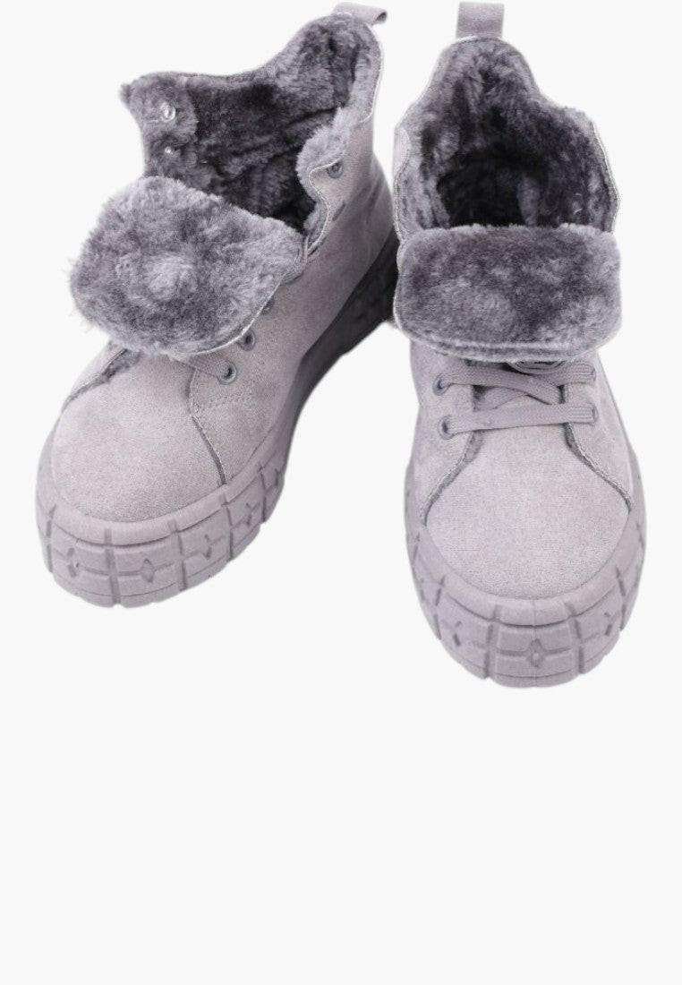 Zbliżenie na jasno szare ocieplane sneakersy damskie z futrzaną podszewką.
