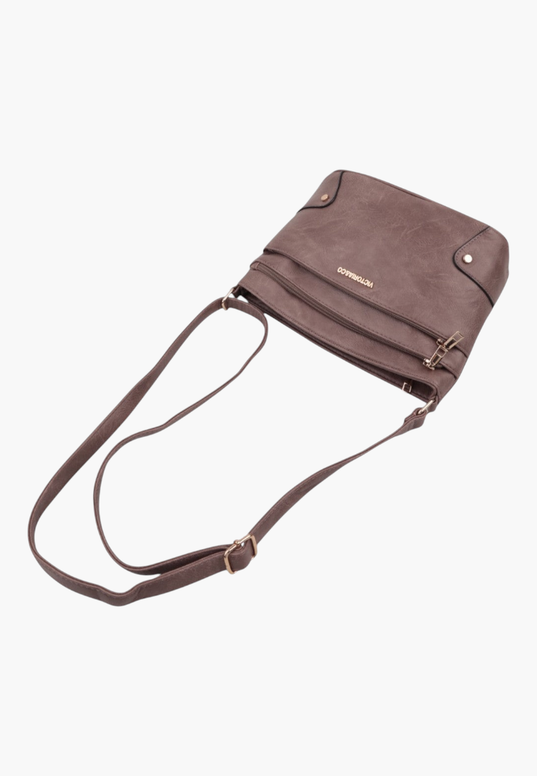 Szczegółowy widok brązowej torebki listonoszki z wieloma kieszeniami.