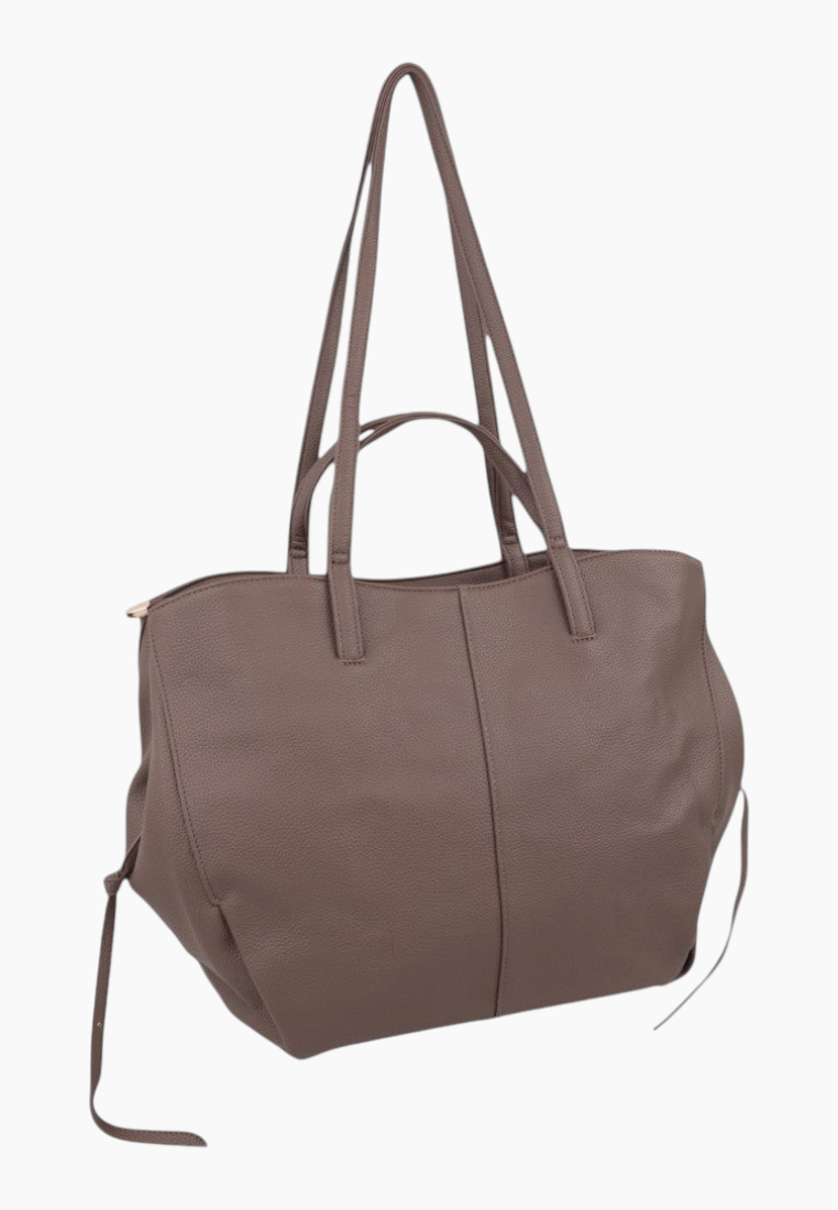 Widok z boku brązowej torebki typu shopper z dwoma uchwytami na białym tle.