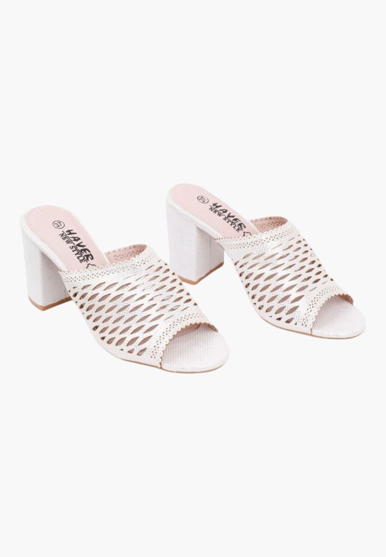Lifestyle shot of white heeled sandals with woven design and open toe on a white background