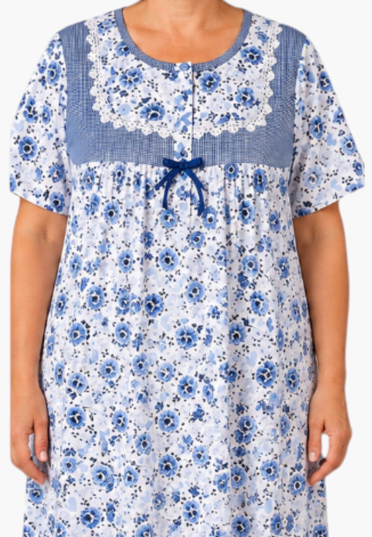 Koszula nocna plus size z niebieskim kwiatowym wzorem na uśmiechniętej kobiecie.