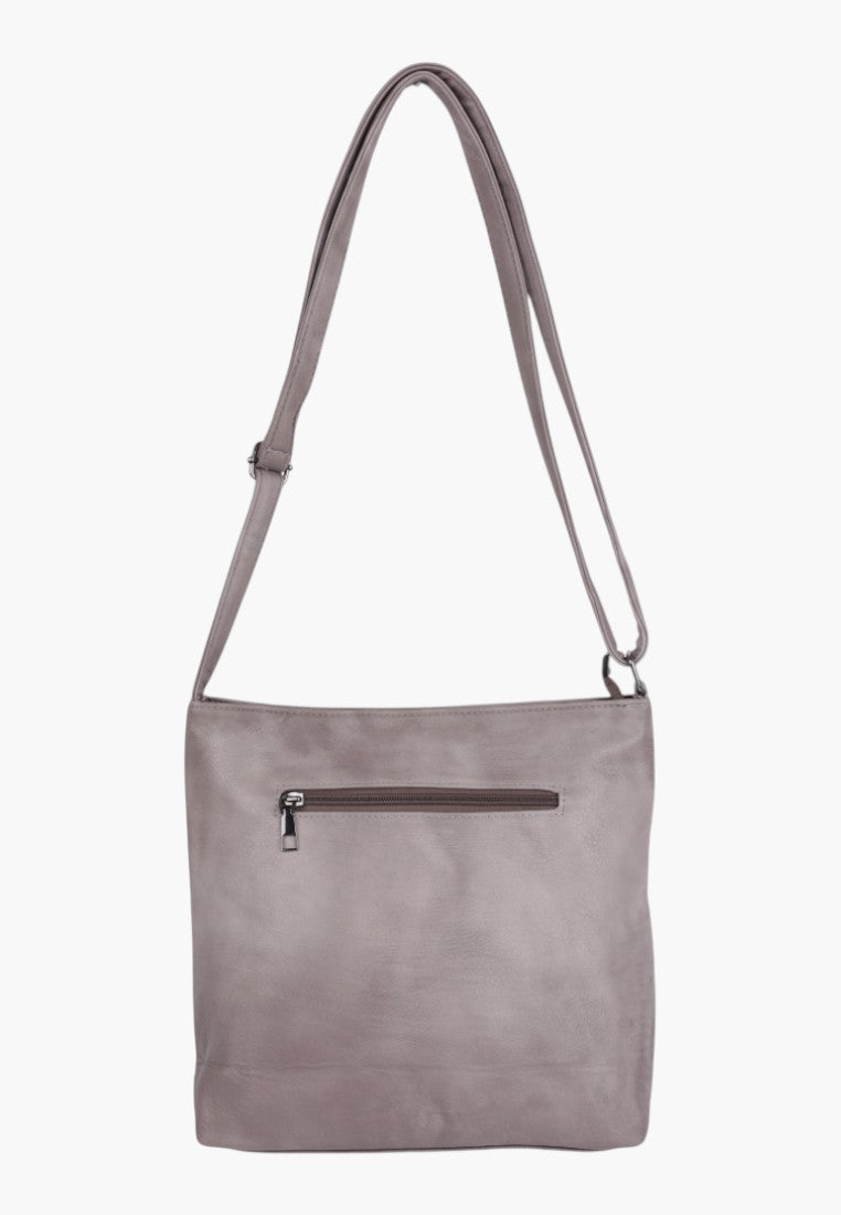 Detail shot of a light grey faux leather crossbody bag with a zippered front pocket.