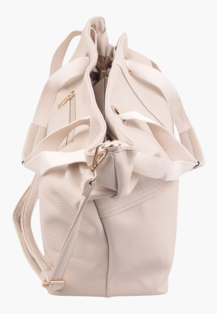 Detail close-up of a light pink handbag showcasing its folded design.
