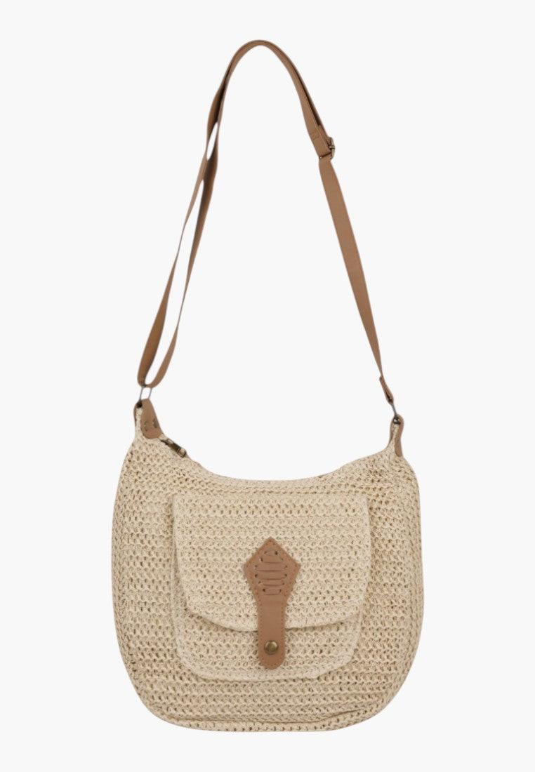 Side view of a beige crossbody bag featuring an adjustable strap and flap closure.