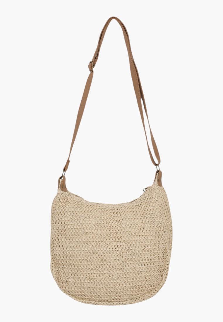 Top view detail of a beige crossbody bag with a flap closure.