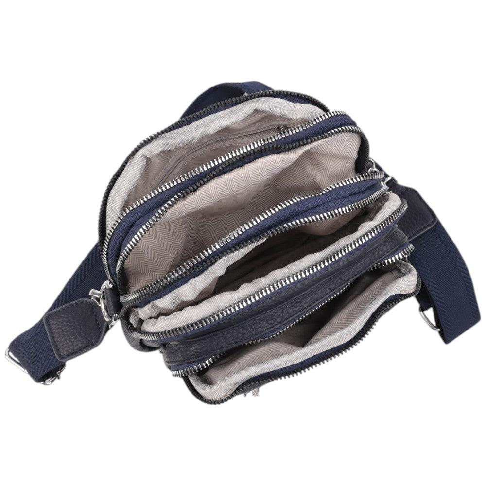Close-up detail of a black crossbody bag showing zippered compartments and textured fabric.