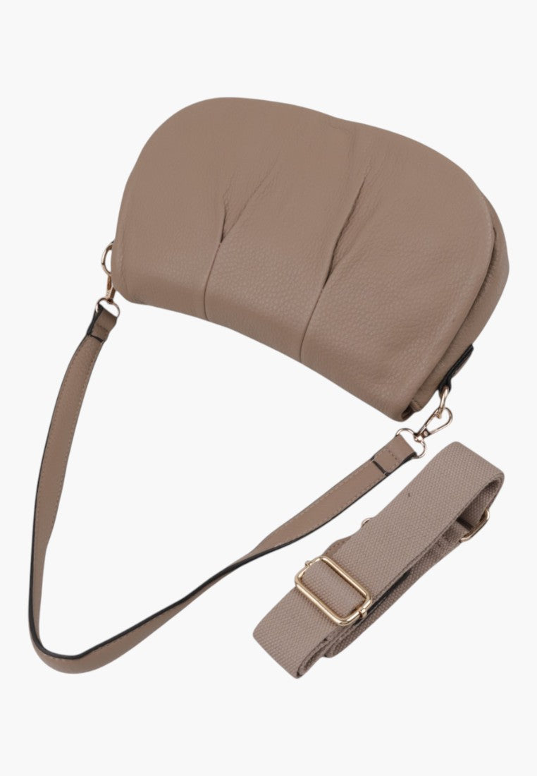 Side view of the brown handbag with adjustable strap on a white background.