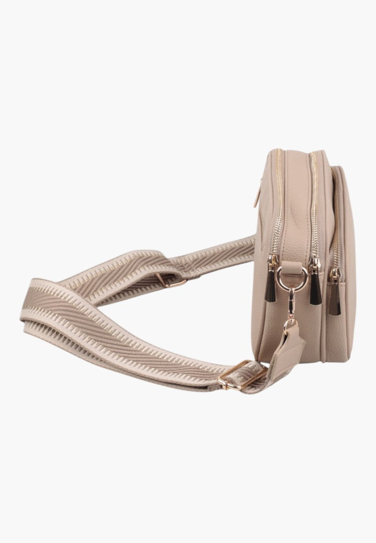 Detail shot of a khaki handbag showing interior pocket and zipper closure.