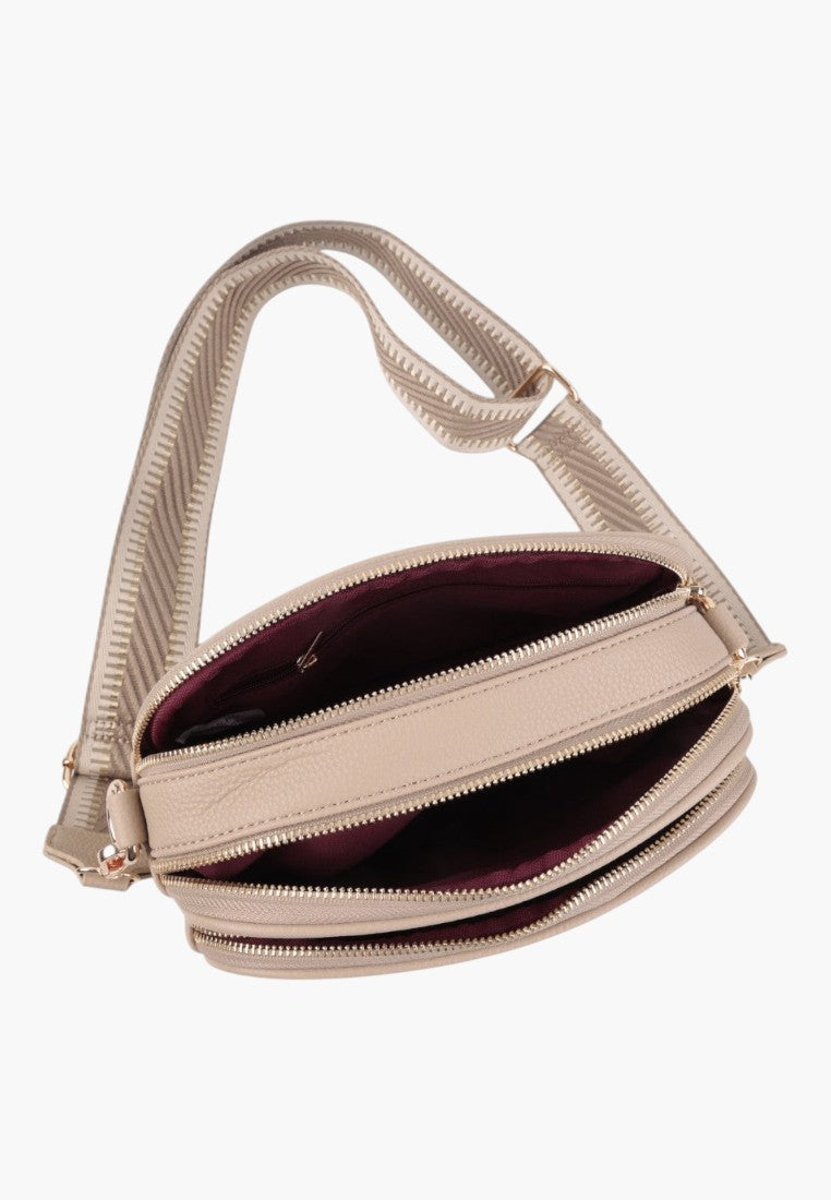Side view of a khaki handbag with structured design and adjustable strap.