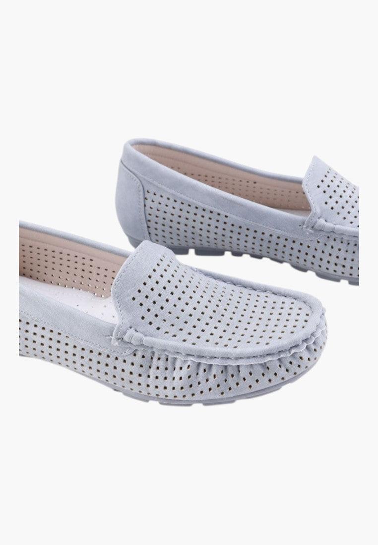 Side view of white slip-on shoes with flat sole and no laces.