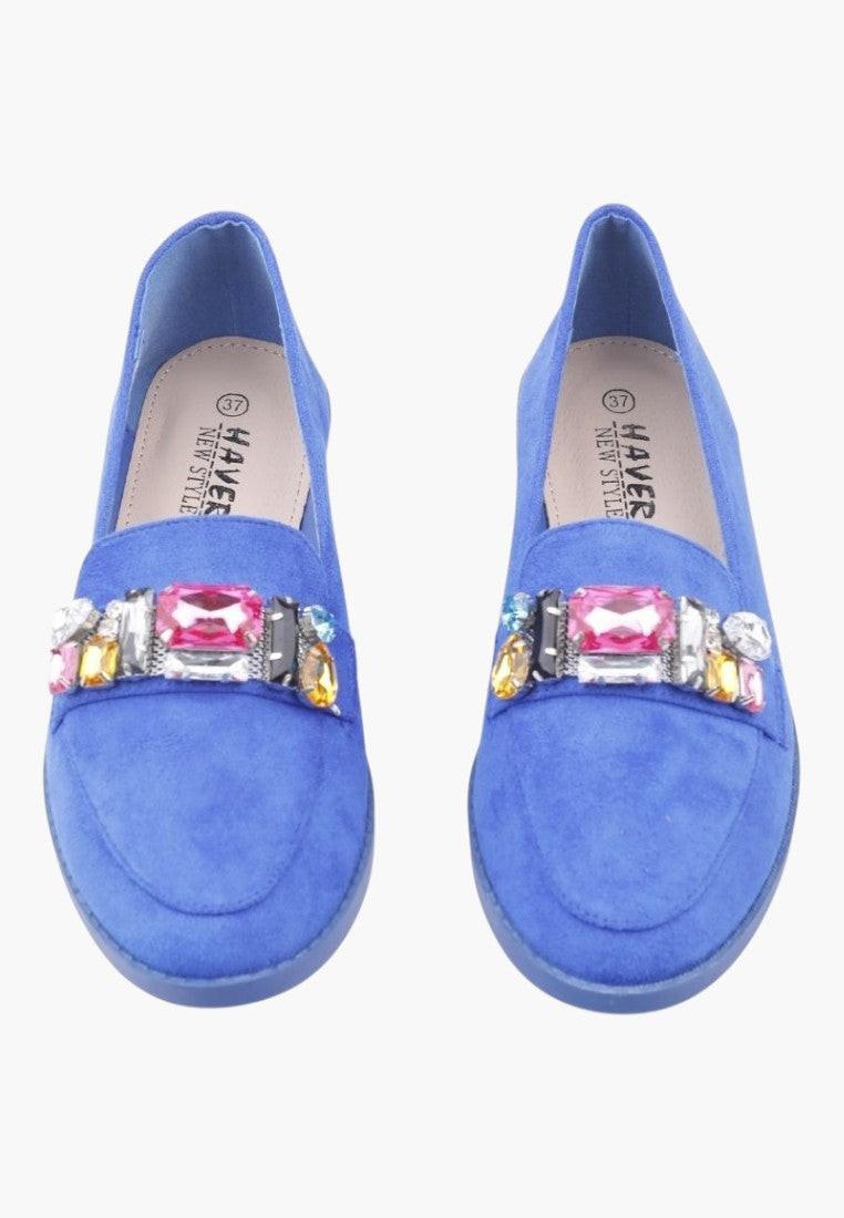 Close-up detail of blue moccasin shoes highlighting textured surface and decorative strap.