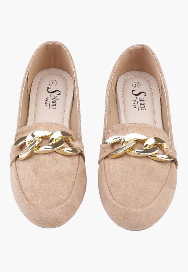 Close-up detail of beige suede loafers with gold chain