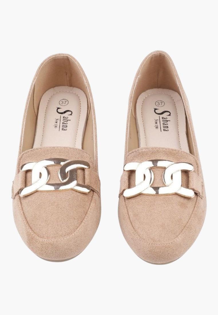 Top view detail of beige suede loafers showcasing soft material and decorative buckle.