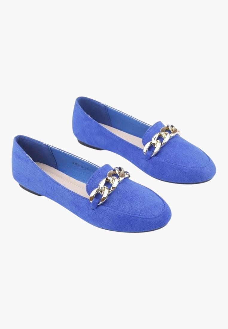 Front view of blue suede flat shoes with decorative buckle.