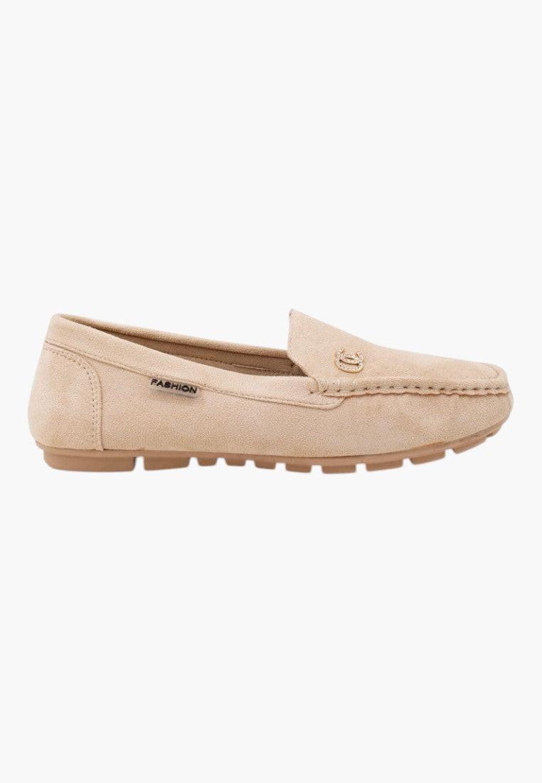 Close-up detail of beige slip-on shoes highlighting soft material.