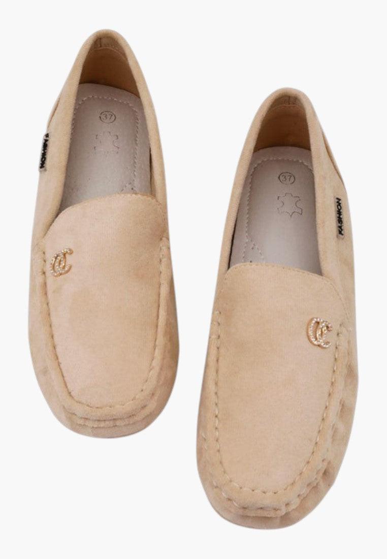 Top view of beige slip-on shoes with a flat sole.