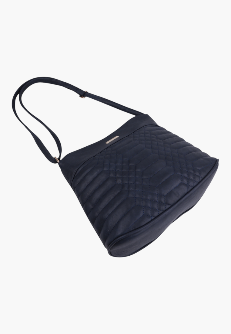 Side view of navy blue faux leather crossbody bag with quilted design and adjustable strap.