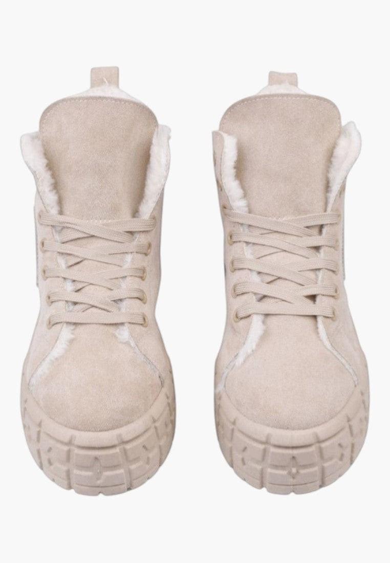 Detal beżowych sneakersów damskich z teksturowaną podeszwą.