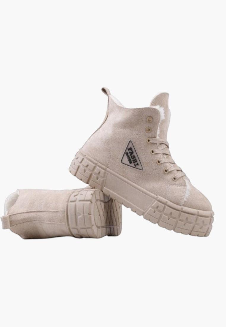 Detal beżowych sneakersów damskich z logo po boku.