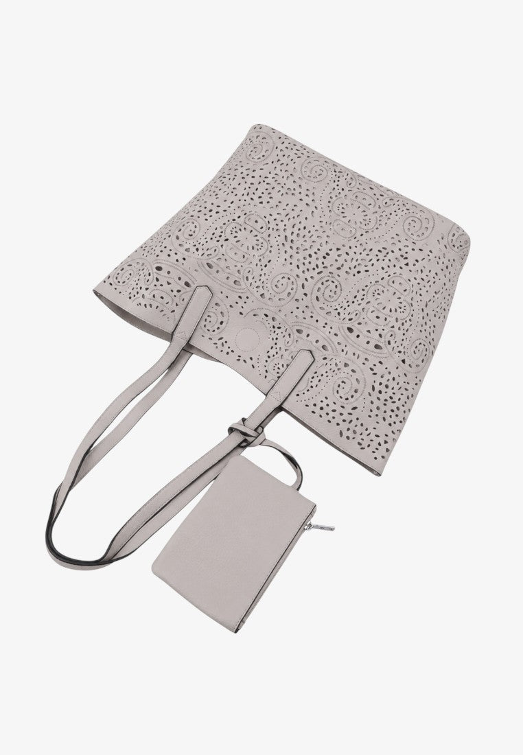 Lifestyle shot of a light gray tote bag featuring an embossed pattern and detachable tag.