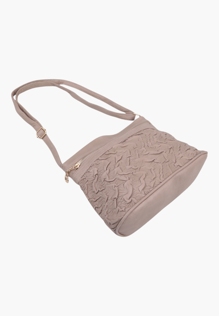 Side view of a beige handbag showcasing a slouchy shape and zipper pocket.