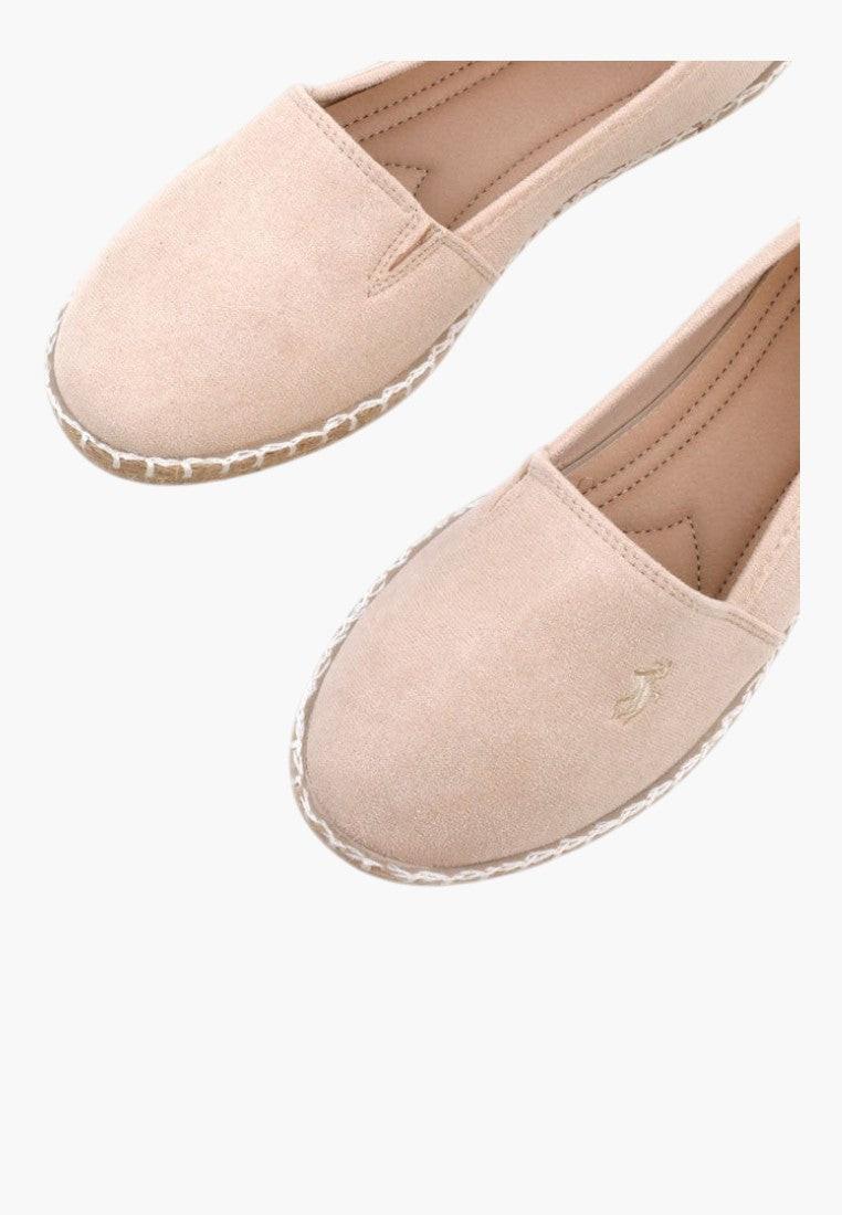 Close-up detail of pink slip-on espadrilles showing soft fabric and flat sole
