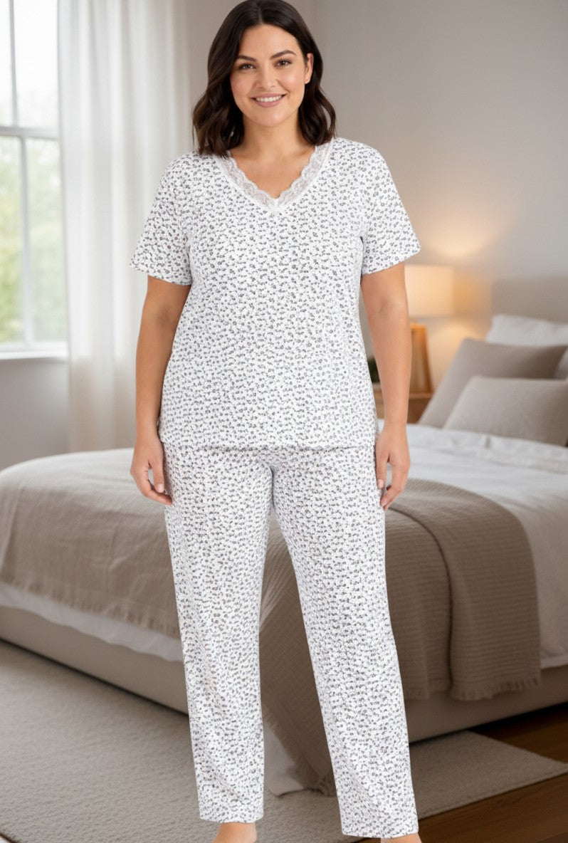 Lifestyle view of a floral cotton pajama set featuring short sleeves and a lace V-neck.