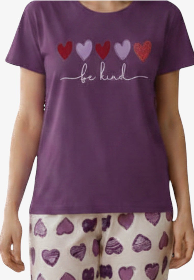 Detail close-up of the pajama top showcasing a heart design and text detail in purple, white, and red.