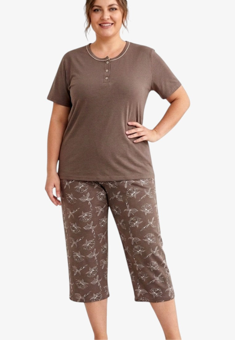 Lifestyle shot of a brown pajama set with short sleeves and cropped pants on a white background.