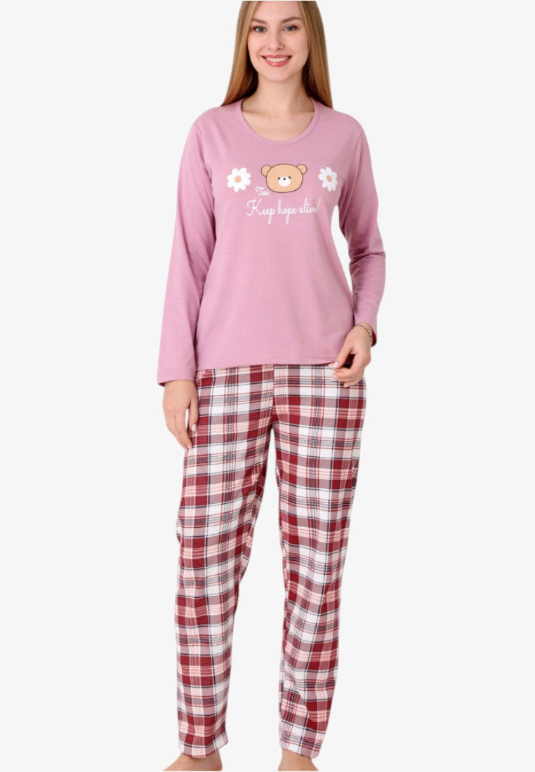 Lifestyle shot of women's insulated cotton pajama set in pink with bear print and plaid trousers.