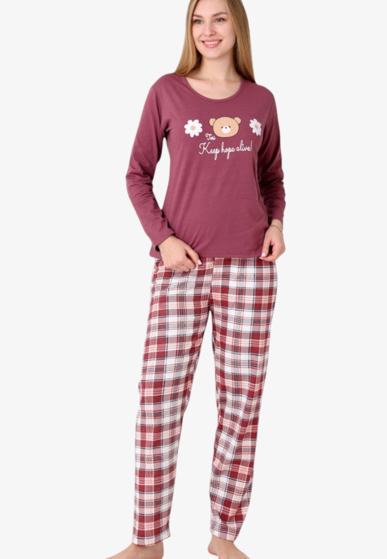 Lifestyle shot of a women's insulated cotton pajama set featuring a bear graphic and plaid pants.