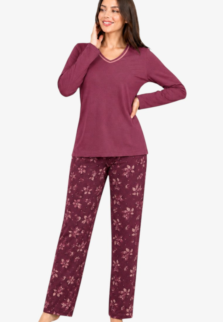 Lifestyle shot of burgundy cotton pajama set with long sleeves and floral print trousers.