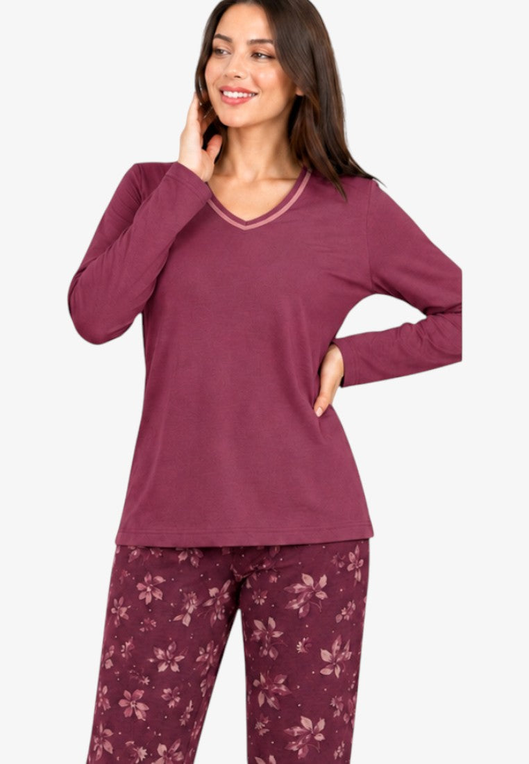 Lifestyle shot of burgundy cotton pajama set with long sleeves and floral print trousers.