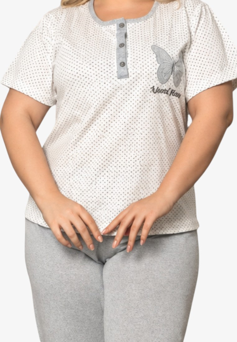 Detail view of the white polka dot cotton pajama top with short sleeves and grey 3/4 pants.
