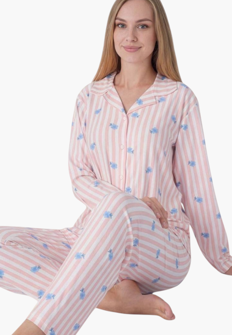 Lifestyle view of a striped pajama set in pink, blue, and white featuring a button-up top.