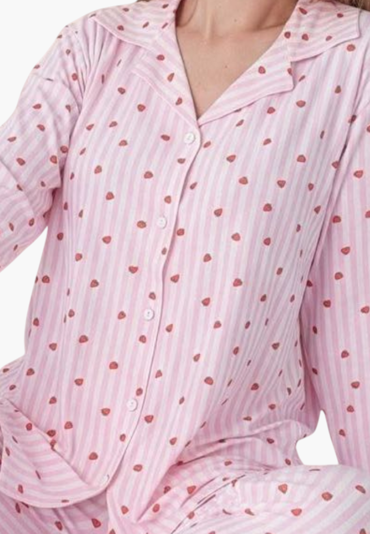 Lifestyle shot of a pink pajama set with polka dots and button closure.