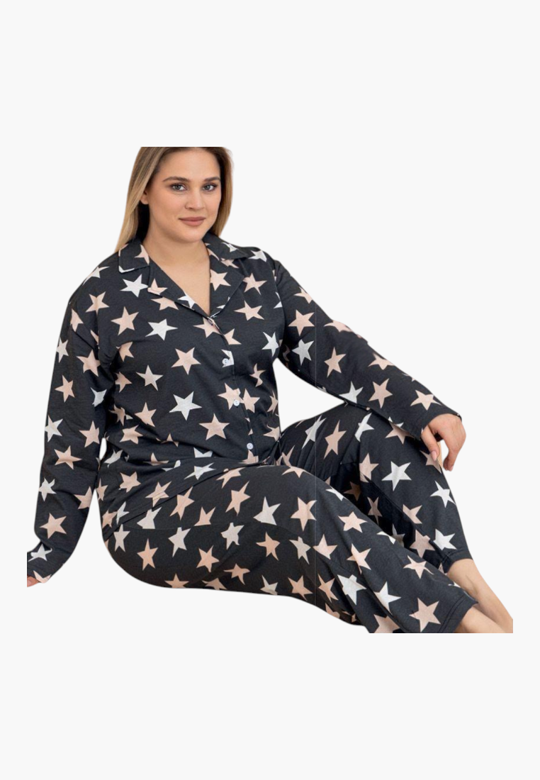 Lifestyle shot of navy, pink, and white star-patterned pajamas featuring long sleeves and a loose fit.