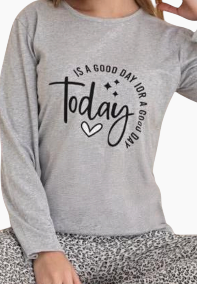 Detail close-up of a gray pajama top with printed text and long sleeves.
