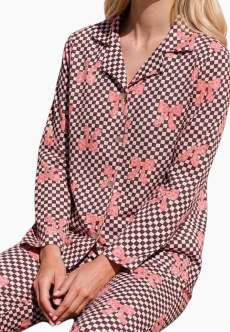 Lifestyle shot of a pink and brown floral pajama set with a button-up top.