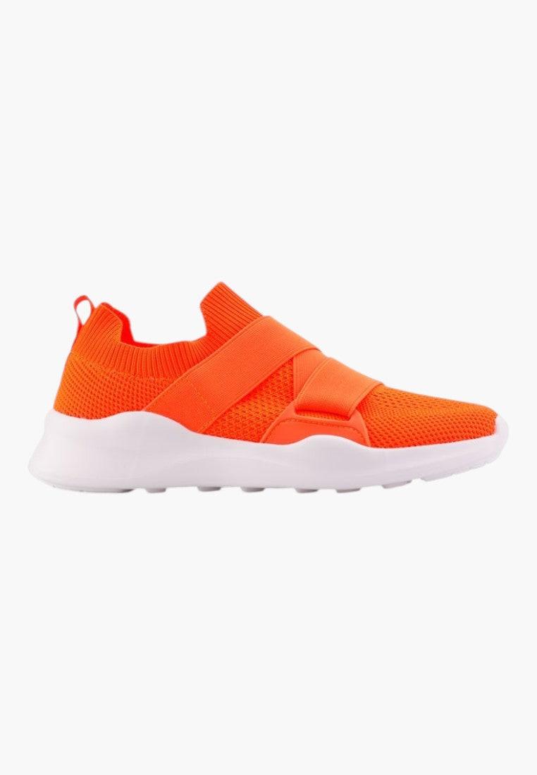 Lifestyle shot of orange athletic shoes showcasing slip-on design and mesh upper.
