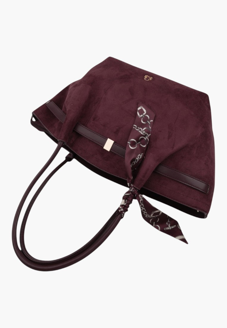 Detail shot of a burgundy faux suede shopper bag with a decorative patterned scarf.
