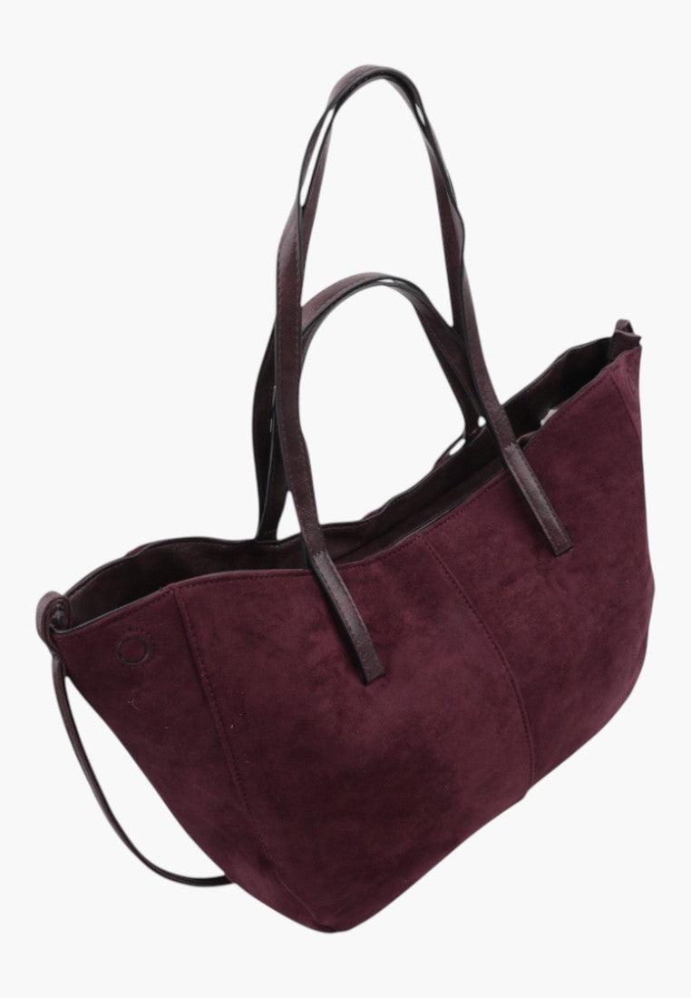 Widok z boku dużej torebki shopper w burgundowym kolorze z długimi paskami.