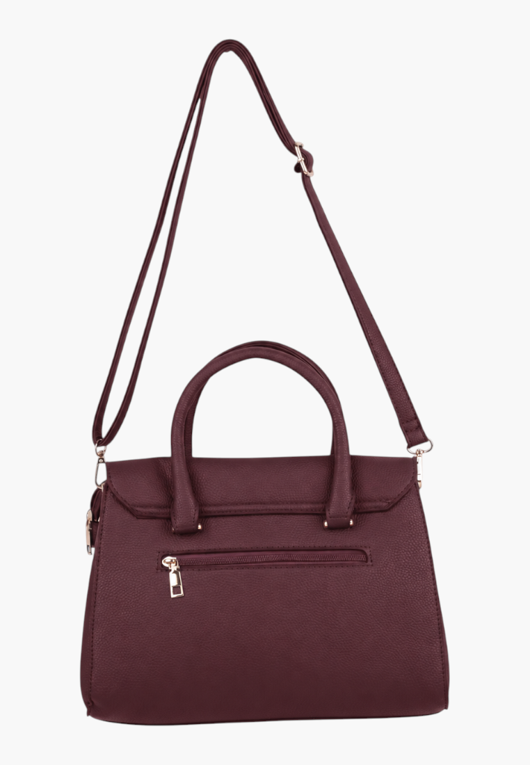 Side view of a burgundy handbag with top handles and gold hardware on a white background.