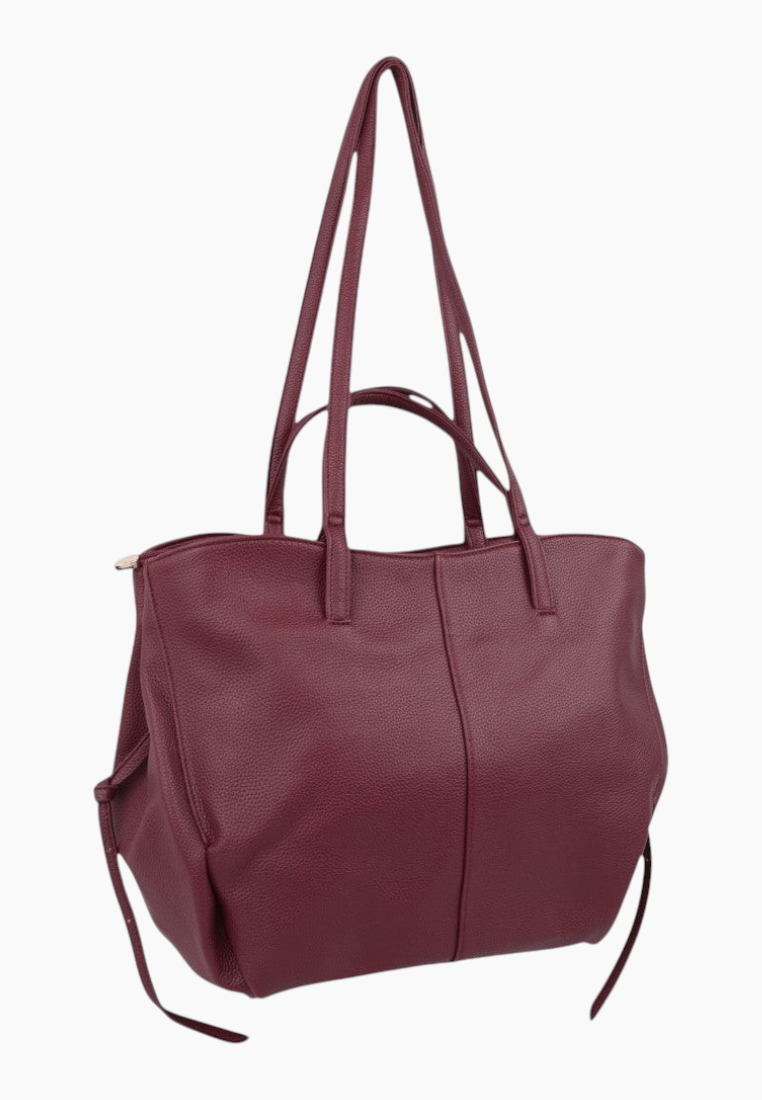 Side view of a burgundy handbag showcasing its spacious design and two handles.