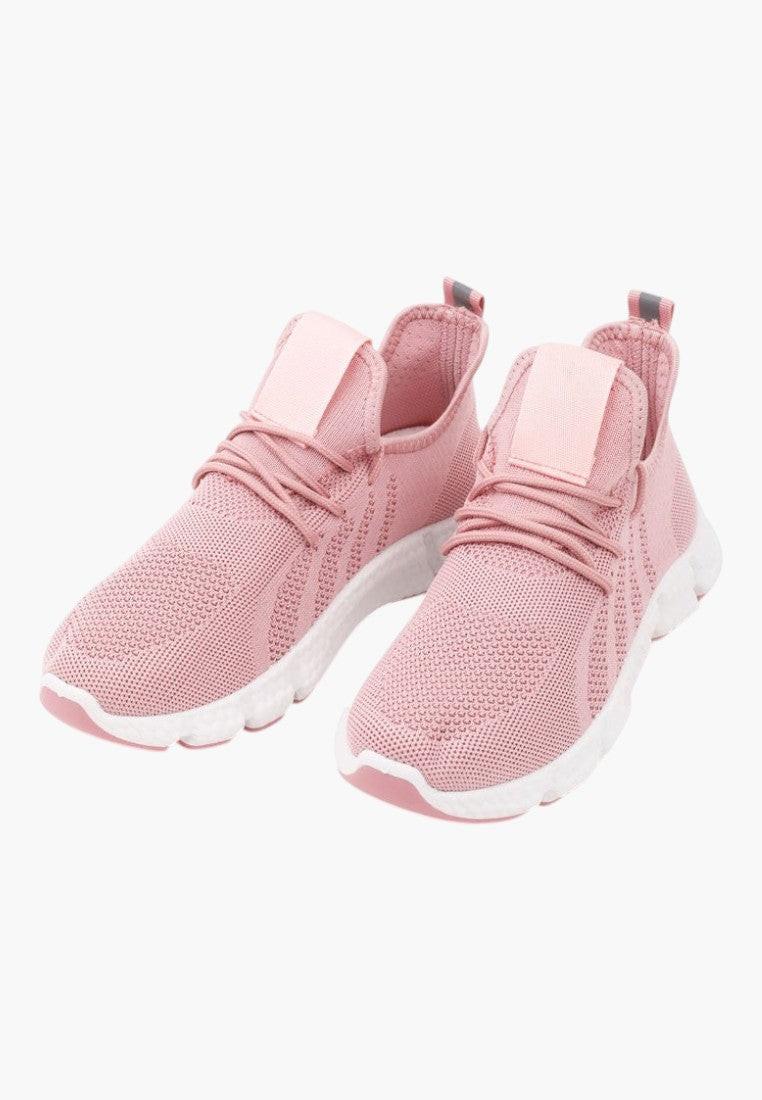 Różowe buty sportowe z elastyczną cholewką w stylu życia na białym tle
