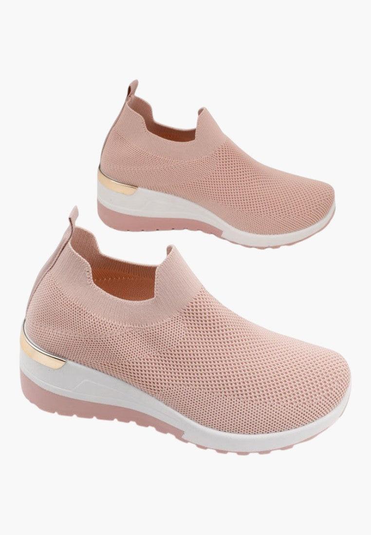 Zbliżenie na różowe sneakersy damskie z detalem i teksturowanym materiałem.
