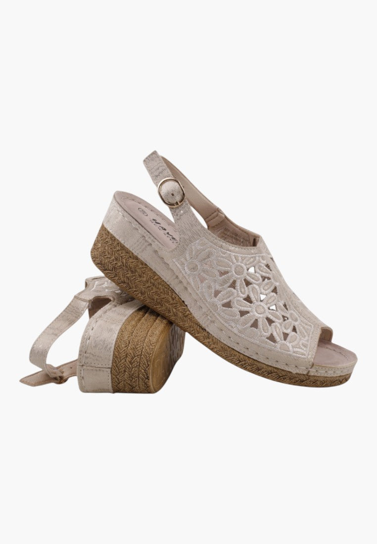Side view of beżowych sandałów damskich na koturnie z zapięciem typu slingback i drewnianym obcasem.